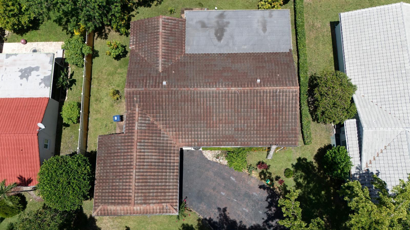 Barrel tile roof of a Pembroke Pines home covered in black algae streaks before washing