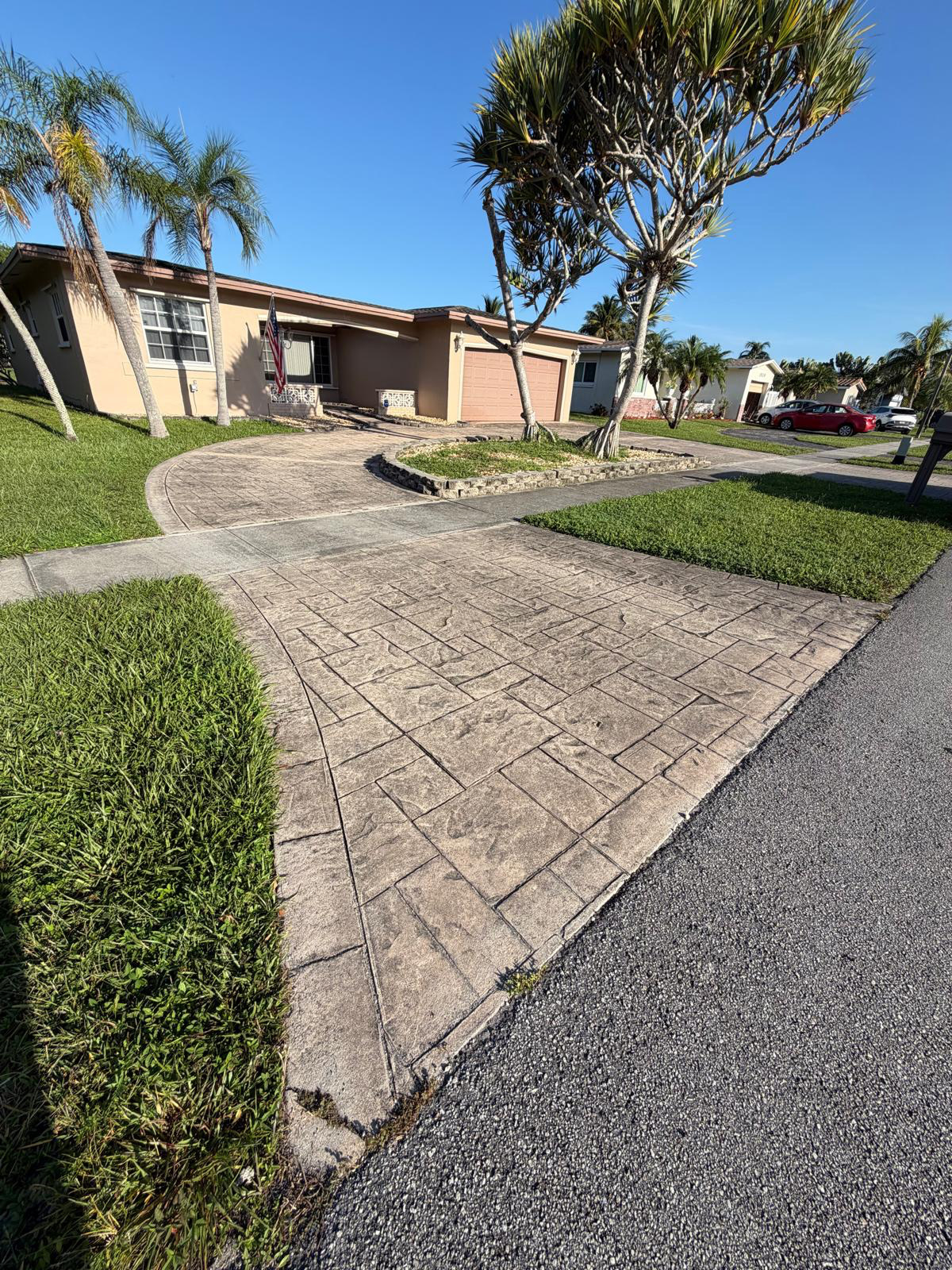 Stamped concrete driveway in Weston darkened by mold and dirt before pressure washing